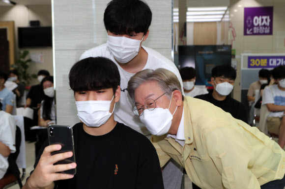 이재명 경기도지사가 12일 경기도 파주시 운정 예방접종센터에서 백신 접종을 위해 센터를 찾은 수험생들과 기념촬영하고 있다. 2021.8.12  연합뉴스