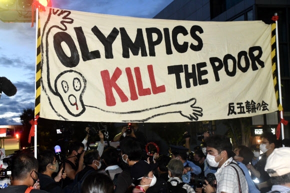 2020 도쿄올림픽 폐회식이 진행된 지난 8일 일본 도쿄 내셔널 스타디움 밖에서 대회를 개최하는 것에 반대하는 시민들이 ‘올림픽은 가난한 사람을 죽인다’는 현수막을 들고 시위를 벌이고 있다. 도쿄 연합뉴스 