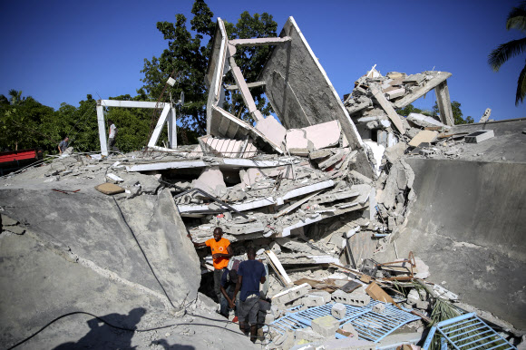 아이티 사람들이 14일 진도 7.2의 지진이 휩쓸고 간 잔해에서 생존자를 찾고 있다. 연합뉴스.