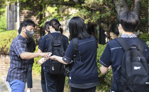 일선 학교의 2학기 개학이 본격적으로 시작되는 17일 서울 시내 한 고등학교에서 2~3학년 학생들이 등교하고 있다. 학생들은 교정에 들어서며 손소독과 체온 측정을 하고 각자의 교실로 들어갔다. 2021.08.17 사진공동취재단
