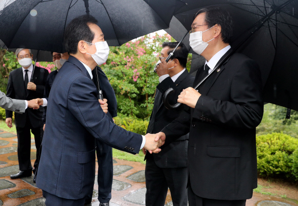 더불어민주당 대선 예비후보인 정세균 전 국무총리(왼쪽)가 김대중 전 대통령 서거 12주기를 맞아 18일 오전 국립서울현충원 고 김 전 대통령 묘역에서 참배를 마친 뒤 차남인 김홍업 김대중평화센터 이사장과 악수를 나누고 있다.2021. 8. 18 김명국 선임기자 daunso@seoul.co.kr