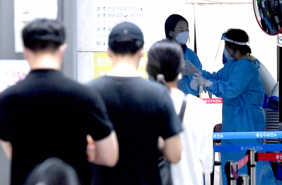 18일 서울 용산구청에 마련된 선별진료소를 찾은 시민들이 코로나19 검사를 위해 줄을 서 있다. 2021.8.18  박지환 기자 popocar@seoul.co.kr
