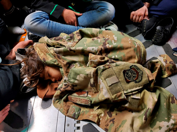 미군 수송기 바닥서 군복 덮고 잠든 아프간 어린이