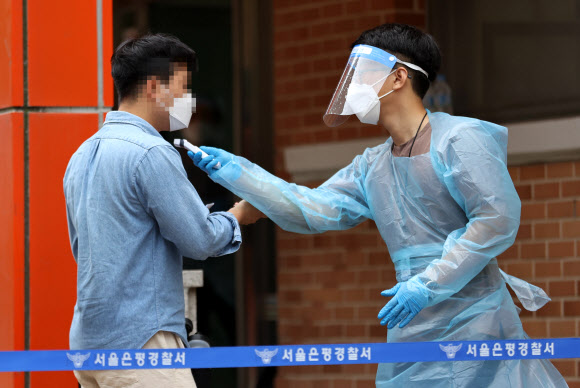 21일 서울 은평구 진관중학교에서 열린 2021년도 제2차 경찰공무원 채용 필기시험에서 한 응시생이 체온측정을 하고 있다. 2021.8.21  연합뉴스