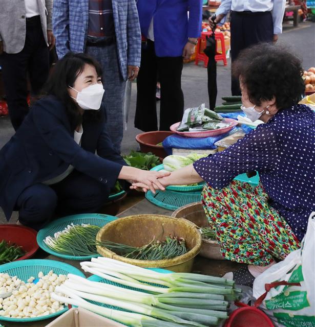 더불어민주당 대권 주자인 이재명 경기도지사의 부인 김혜경씨가 21일 전북 전주시 중앙시장에서 한 상인의 손을 잡고 대화를 나누고 있다. 2021.8.21 뉴스1