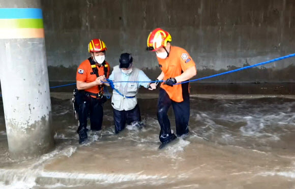 21일 낮 부산 금정구 부곡동 온천천에서 119구조대가 급류에 고립된 시민을 구조하고 있다. 2021.8.21  부산소방본부 제공