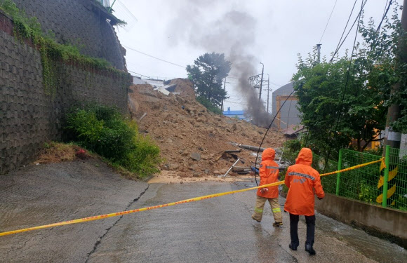 21일 오후 1시 47분께 경남 양산시 장기터2길 공장 일대에서 옹벽이 무너지며 도로 위로 토사가 쏟아져 소방당국 관계자들이 현장을 통제하고 있다. 2021.8.21  경남도소방본부 제공