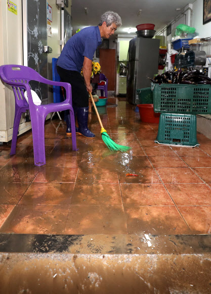 흙탕물 쓸어내는 태화시장 상인