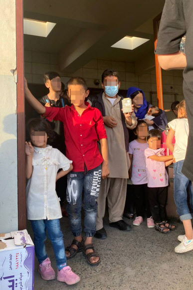 한국 정부와 협력한 아프가니스탄인들이 카불공항에 도착한 공군 수송기에 탑승하기 전 우리 외교부로부터 받은 여행증명서를 보여주고 있다. 2021.8.25  외교부 제공