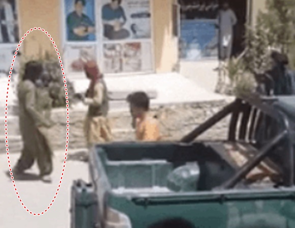 지난 20일 아프간 수도 카불 거리에서 탈레반이 아프간 청년(빨간 원)의 복장이 불량하다고 지적하며 총구로 공격하고 있다. 트위터 캡처