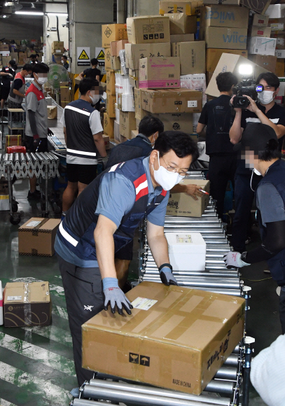 더불어민주당 송영길 대표가 26일 오전 서울 금천구에 위치한 롯데글로벌로지스구로터미널 택배 현장을 찾아 근로자들과 택배 분리작업을 하고 있다.2021. 8. 26  김명국 선임기자 daunso@seoul.co.kr