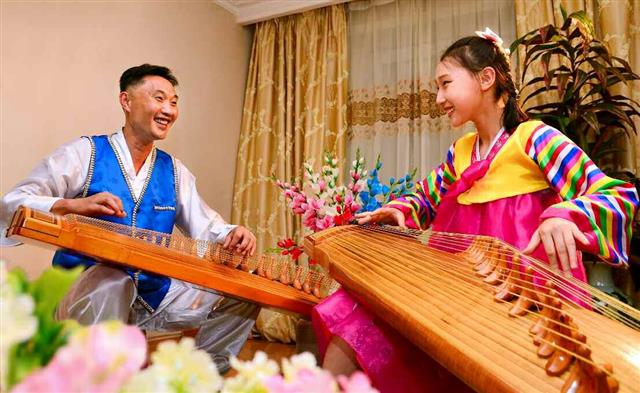 북한 노동당 기관지 노동신문은 26일 “우리 인민의 우수한 민족전통을 적극 살려 나가자”라고 보도했다. 사진은 가야금 연주자인 경남철이 그의 딸에게 가야금을 가르치는 모습.  평양 노동신문 뉴스1