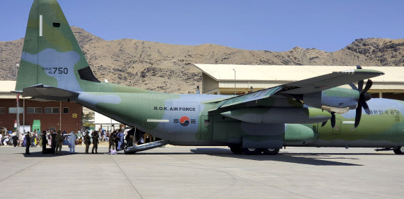 한국으로 이송될 아프간 현지 조력자와 가족들이 25일 아프가니스탄 카불공항에서 공군 C-130J 수송기에 탑승하고 있다. 2021.8.26  공군 제공