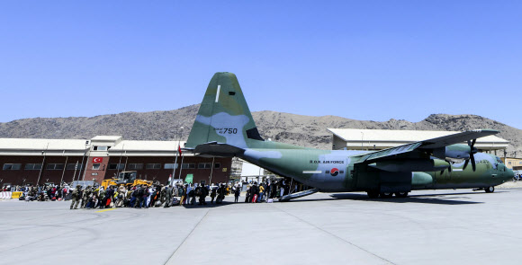 한국으로 이송될 아프간 현지 조력자와 가족들이 25일 아프가니스탄 카불공항에서 공군 C-130J 수송기에 탑승하고 있다. 2021.8.26  공군 제공