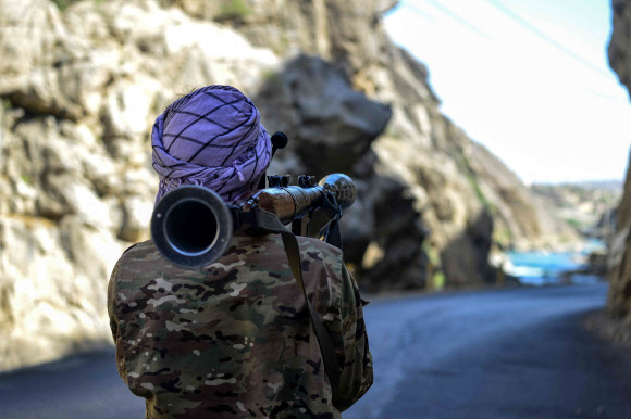 아프가니스탄 반 탈레반 저항군이 25일(현지시간) 아프간 북부 판지시르주의 라에탕 지구 도로에서 무기를 들고 경계 근무를 서고 있다. AFP 연합뉴스