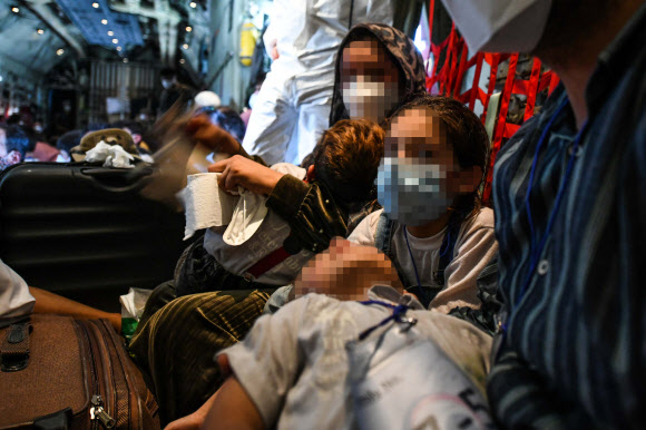 한국으로 이송될 아프간 현지 조력자와 가족들이 25일 아프가니스탄 카불공항에서 공군 C-130J 수송기에 탑승해 있다. 2021.8.26  공군 제공