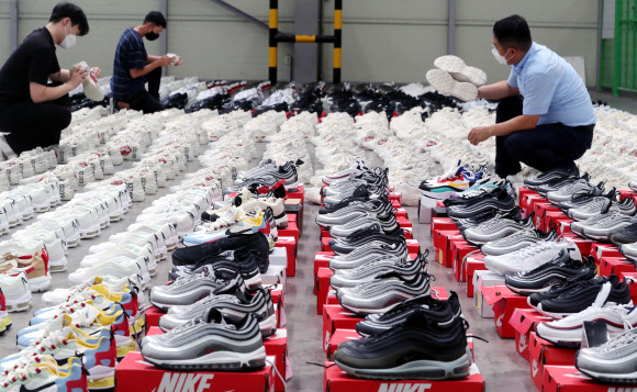 26일 부산 강서구 부산세관신항지정장치장에서 직원이 해외 유명 브랜드 제품을 본떠 만든 중국산 ‘짝퉁’ 운동화 압수품을 공개하고 있다. 부산본부세관은 나이키, 구찌, 발렌시아가 등 해외 유명 브랜드 위조 상표 운동화 2천 켤레(정품 시가 17억 원어치)를 밀수입해 ‘000 스마트스토어’ 등 유명 오픈마켓에서 정품인 것처럼 판매한 일당 3명을 붙잡아 1명을 구속했다고 밝혔다. 2021.8.26  연합뉴스