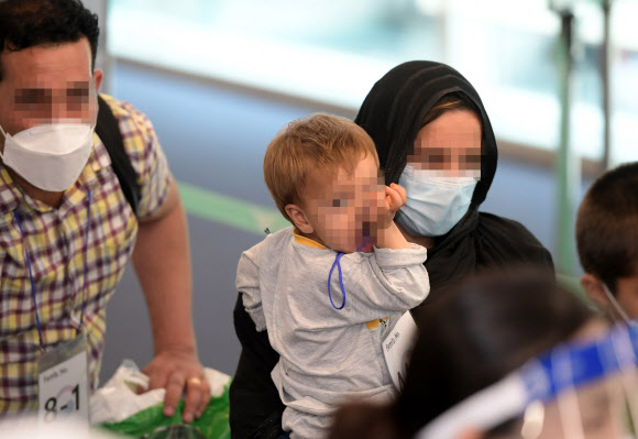 과거 한국을 도왔던 아프가니스탄 협력자와 그 가족들이 26일 오후 우리 공군 수송기에 탑승해 인천공항에 도착, 코로나19 유전자 증폭(PCR) 검사를 받기 위해 보안구역으로 이동하고 있다. 2021.8.26  사진공동취재단