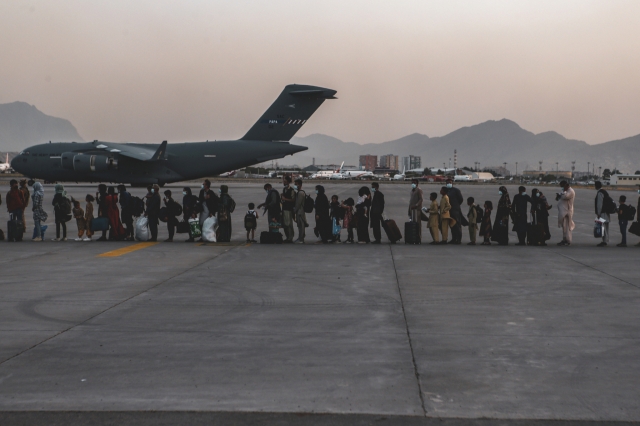 아프가니스탄 수도 카불의 하미드 카르자이 국제공항에서 지난 23일(현지시간) 탈레반의 탄압을 피해 탈출하려는 시민들이 미군 C-17 수송기에 탑승하기 위해 줄지어 서 있다(위 기사와 관련 없음). 연합뉴스 