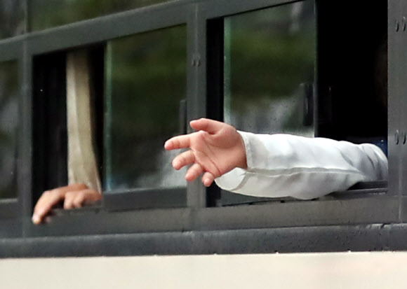 과거 한국을 도왔던 아프가니스탄 협력자와 가족들이 27일 오전 임시격리시설인 경기도 김포의 한 호텔에서 버스를 타고 충북 진천으로 출발하면서 비가 내리는지를 확인하고 있다. 이들은 진천 국가공무원인재개발원에서 6주간 생활하며 한국 사회 적응을 위한 교육을 받을 예정이다. 2021.8.27  연합뉴스