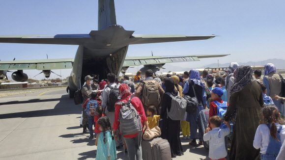 한국으로 이송될 아프간 현지 조력자와 가족들이 25일 아프가니스탄 카불공항에서 공군 C-130J 수퍼허큘리스 수송기에 탑승하기 위해 대기하고 있다. 2021.8.26  사진=공군제공