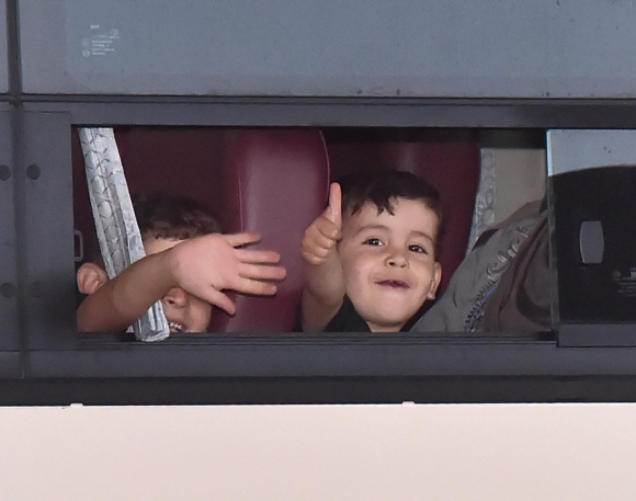한국 도운 아프칸인들이 26일 오후 인천공항을 통해 입국 했다. 버스에 탑승한 어린이가 취재진에게 손 흔들어 인사하고 있다. 2021.8.27 박윤슬기자 seul@seoul.co.kr