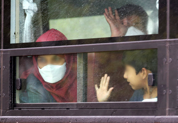 과거 한국을 도왔던 아프가니스탄 협력자와 그 가족들을 태운 버스가 27일 오후 충북 진천 국가공무원인재개발원로 들어서자 한 가족이 차장 밖으로 손 흔들고 있다.   이들은 이곳에서 약 6주간 생활하며 한국어와 한국 문화 등 사회 적응을 위한 교육을 받을 예정이다. 2021.8.27  연합뉴스