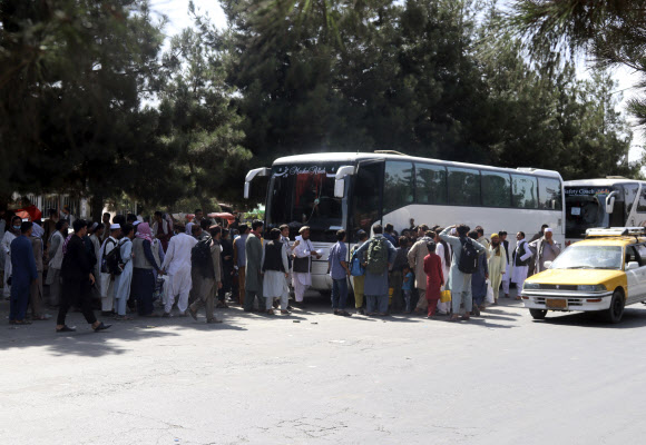 27일(현지시간) 아프간 탈출을 위해 카불 공항으로 들어가려 버스주위에 모인 사람들. AP
