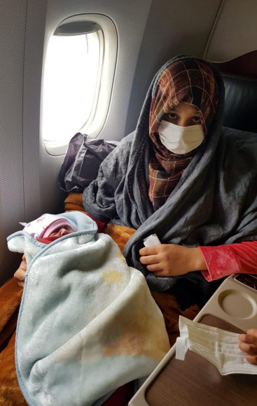 아랍에미리트(UAE) 두바이를 28일(현지시간) 출발해 영국 버밍엄으로 향하던 터키항공 여객기 안에서 건강한 딸아이 하바를 낳은 아프가니스탄 탈출 여성 소만 누리가 아이를 안은 채 카메라를 응시하고 있다. 터키항공 제공 AP 연합뉴스 