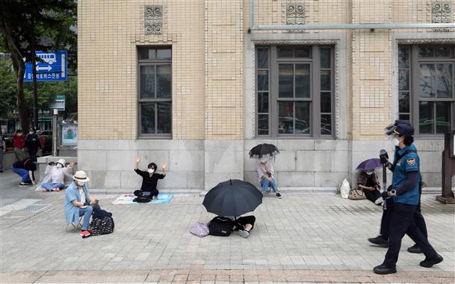 사랑제일교회 신도 등이 29일 오전 서울 광화문 일대에서 온라인을 통해 생중계되는 주일예배를 시청하고 있다..  한편 사랑제일교회는 성북구청의 시설폐쇄 명령이 이뤄진 지난 19일 이후 첫 주말인 22일 교회를 폐쇄한 대신 서울역과 서울시청, 광화문 일대에서 경찰 추산 800여명 규모의 야외예배를 진행했었고, 서울시는 전광훈 목사 등 교회 관계자 4명을 방역지침 위반으로 서울경찰청에 고발했다. 2021.8.29 뉴스1