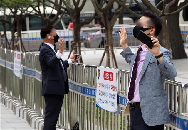 사랑제일교회 신도 등이 29일 오전 서울 광화문 일대에서 온라인을 통해 생중계되는 주일예배를 시청하며 기도하고 있다..  한편 사랑제일교회는 성북구청의 시설폐쇄 명령이 이뤄진 지난 19일 이후 첫 주말인 22일 교회를 폐쇄한 대신 서울역과 서울시청, 광화문 일대에서 경찰 추산 800여명 규모의 야외예배를 진행했었고, 서울시는 전광훈 목사 등 교회 관계자 4명을 방역지침 위반으로 서울경찰청에 고발했다. 2021.8.29 뉴스1