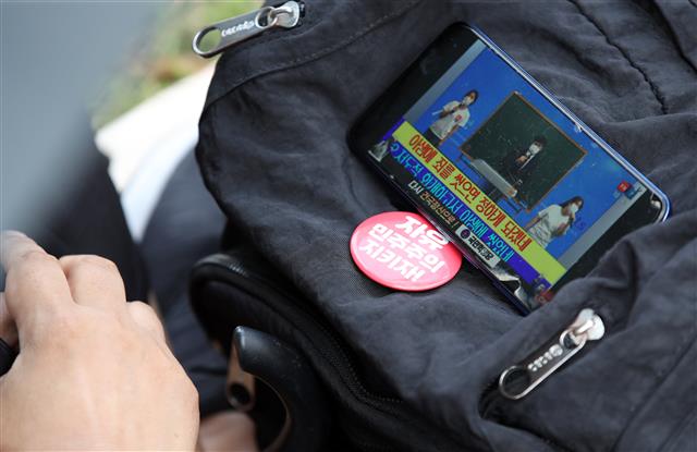 사랑제일교회 신도 등이 29일 오전 서울 광화문 일대에서 온라인을 통해 생중계되는 주일예배를 시청하고 있다..  한편 사랑제일교회는 성북구청의 시설폐쇄 명령이 이뤄진 지난 19일 이후 첫 주말인 22일 교회를 폐쇄한 대신 서울역과 서울시청, 광화문 일대에서 경찰 추산 800여명 규모의 야외예배를 진행했었고, 서울시는 전광훈 목사 등 교회 관계자 4명을 방역지침 위반으로 서울경찰청에 고발했다. 2021.8.29 뉴스1