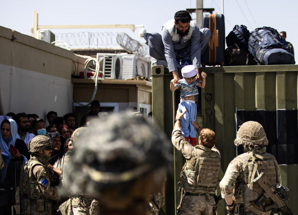 카불 공항서 영국군에 아이 건네는 아프간 남성