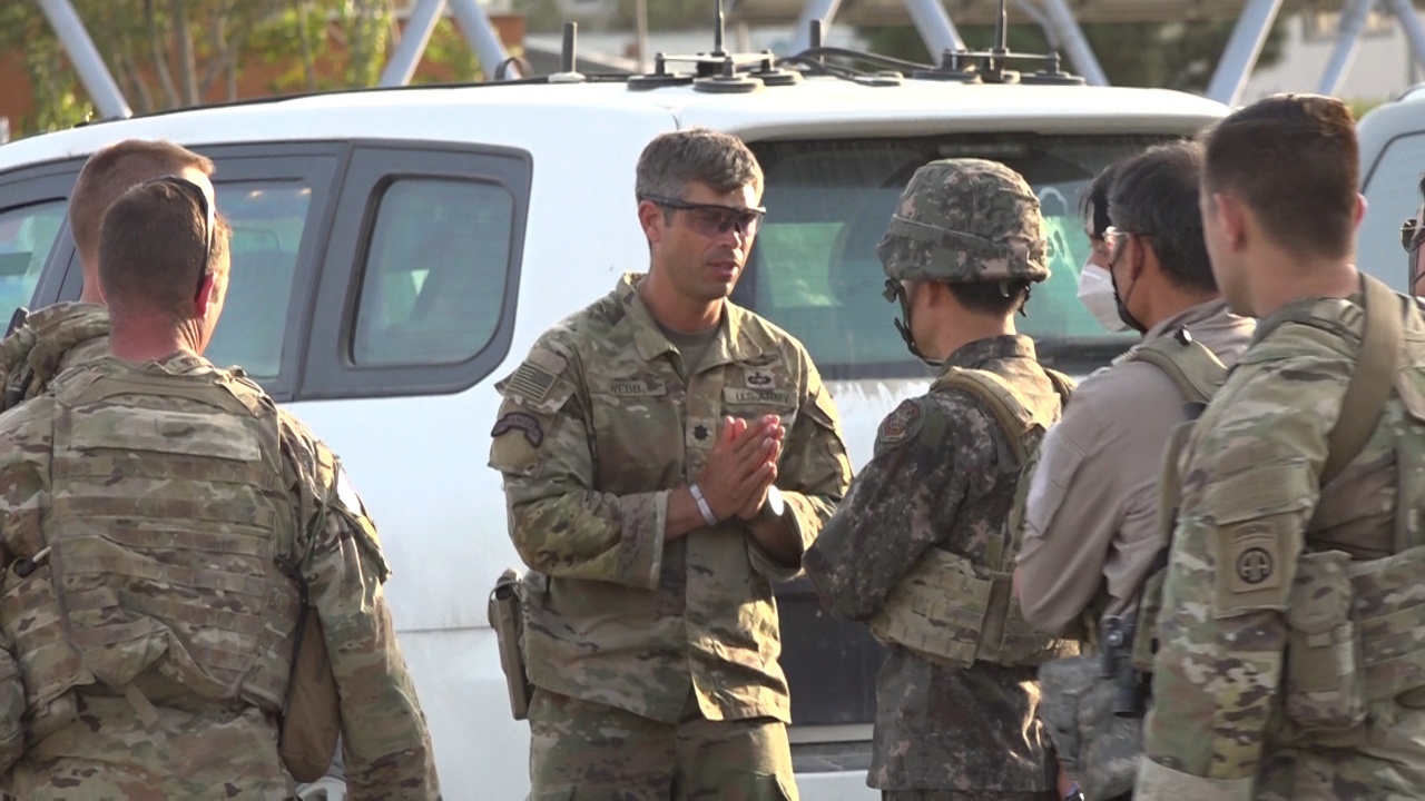 아프가니스탄의 한국인 조력자를 안전하게 데려오는 ‘미라클 작전’의 특수임무단장을 맡은 이경구(왼쪽 네번째) 국방부 국방정책차장이 지난 24일 아프간 카불공항에서 미군 중령과 대화를 나누고 있다. 국방부 제공