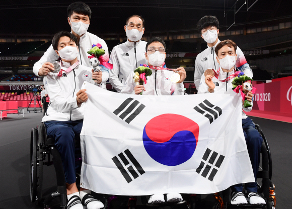 30일 일본 도쿄 메트로폴리탄 체육관에서 열린 2020 도쿄패럴림픽 탁구 남자 단식(스포츠 등급1)에서 금은동을 휩쓴 김현욱 주영대 남기원(왼쪽부터)이 태극기를 함께 들고 기뻐하고 있다. 2021.8.30 도쿄(일본)=사진공동취재단