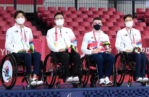 30일 일본 도쿄 메트로폴리탄 체육관에서 열린 2020 도쿄패럴림픽 탁구 남자 단식(스포츠 등급1)에서 금은동을 휩쓴 대한민국 선수들이 시상식에서 메달을 목에 걸고 있다. 왼쪽부터 김현욱(은) 주영대(금, 매튜 토마스(동), 남기원(동). 2021.8.30 도쿄(일본)=사진공동취재단