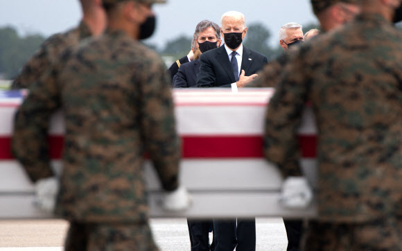미국 델라웨어 도버 공군 기지에서 29일 조 바이든 미국 대통령 부부가 아프가니스탄에서 사망한 미군의 유해를 맞고 있다. 지난 26일 카불 공항의 자살폭탄 테러로 미군 13명이 사망했다. AFP 연합뉴스