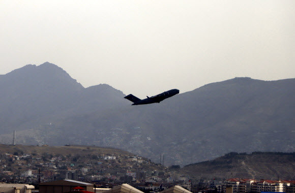 미군이 당초 철군 시한을 하루 앞당겨 30일(현지시간) 자정을 1분여 앞두고 철수를 완료한 가운데 이날 미군 수송기 한 대가 아프가니스탄 수도 카불의 하미드 카르자이 국제공항을 이륙해 솟구치고 있다. 카불 AP 연합뉴스 