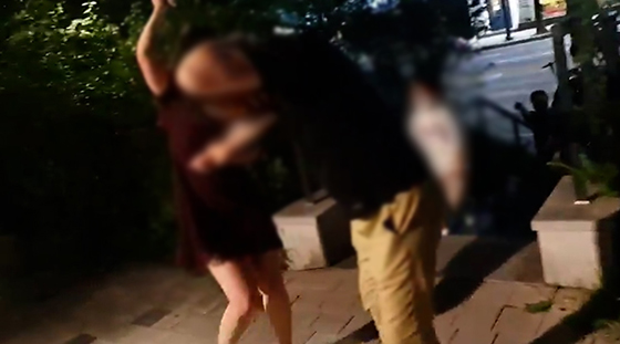 지난 7월 30일 오후 10시 50분쯤 서울 성동구 한 아파트 산책로에서 술에 취한 여성이 한 손에 쥔 휴대전화로 A씨의 머리와 팔 등을 내리치며 폭행하고 있는 모습.