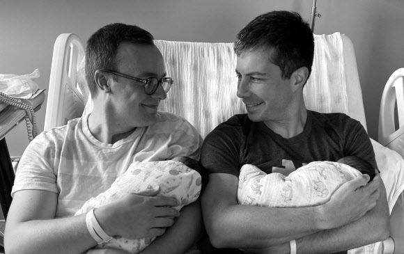 피트 부티지지(오른쪽) 미국 교통장관이 2018년 동성 결혼한 채스턴 글래즈먼과 입양한 아이를 한 명씩 안은 채 서로 마주보며 웃고 있다. 페이스북 캡처·로이터 연합뉴스