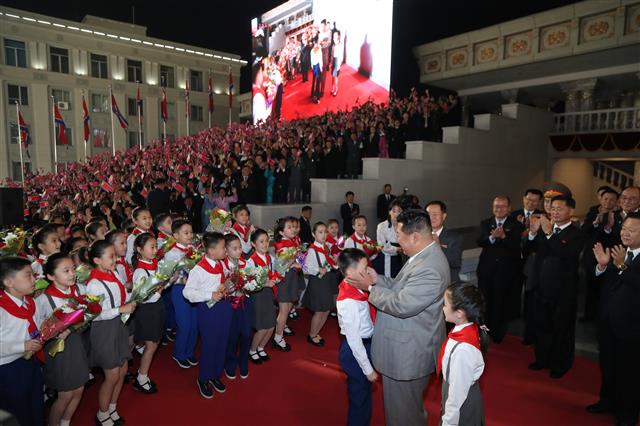 북한 ‘민간 및 안전무력 열병식’…소년단원과 인사하는 김정은