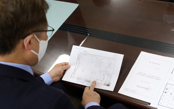 조부의 학생 기록 살피는 최재형