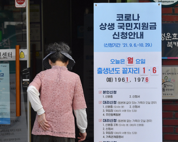 재난지원금 오프라인 신청이 시작된 13일 서울 종로구 청운동 주민센터에 마련된 상담창구로 시민들이 들어서고 있다. 2021.9.13 박지환기자 popocar@seoul.co.kr