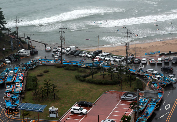 대피한 어선, 파도 즐기는 서퍼