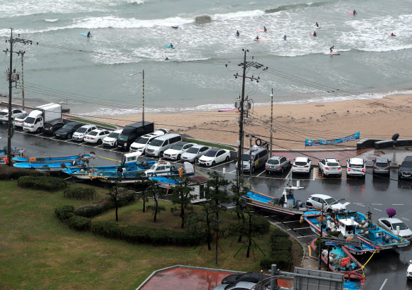 대피한 어선과 태풍 파도 즐기는 서퍼