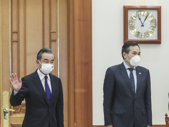 문재인 대통령을 접견하기 위해 15일 오전 청와대를 방문한 왕이 중국 외교부장이 접견 시간보다 3분 늦은 오전 11시 3분에 접견실에 들어서며 취재진에게 손을 흔들고 있다. 오른쪽은 첸커밍 중국 상무부 부부장. 2021. 9. 15 도준석 기자 pado@seoul.co.kr