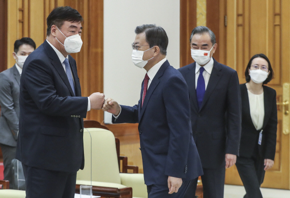문재인 대통령이 15일 청와대에서 왕이 중국 외교부장을 접견했다. 문 대통령이 접견장에 입장하며 싱하이밍 주한 중국대사와 주먹인사하고 있다. 오른쪽 둘째는 왕 부장. 2021. 9. 15 도준석 기자 pado@seoul.co.kr
