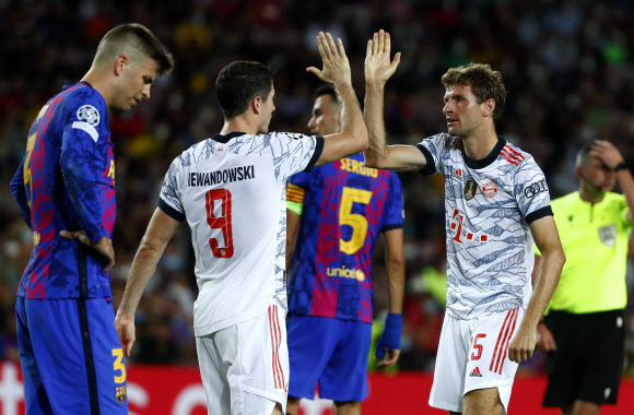 바이에른 뮌헨(독일)의 토마스 뮐러(오른쪽)가 15일(한국시간) 스페인 바르셀로나 캄프 누에서 열린 FC바르셀로나(스페인)와의 2021~22시즌 유럽 챔피언스리그(UCL) 조별리그 1차전 경기에서 후반 11분 쐐기골을 넣은 로베르트 레반도프스키를 축하하고 있다. 바르셀로나 AP 연합뉴스