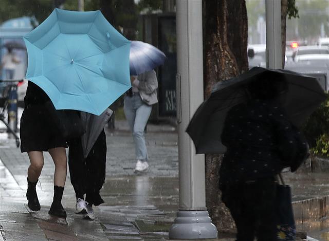 우산 부여잡고 걷는 시민들