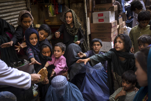 16일(현지시간) 아프가니스탄 카불에서 여성과 아이들이 무료로 빵을 받기 위해 모여 있다. 카불 AP 연합뉴스